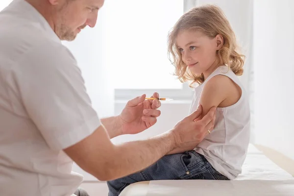 Primer plano de un niño rubio dulce y un médico con una jeringa — Foto de Stock