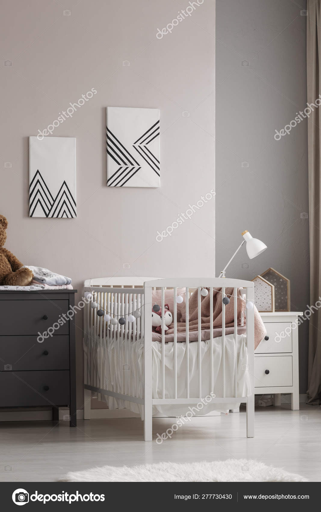 Vertical View Of White Crib With Pastel Pink Bedding And