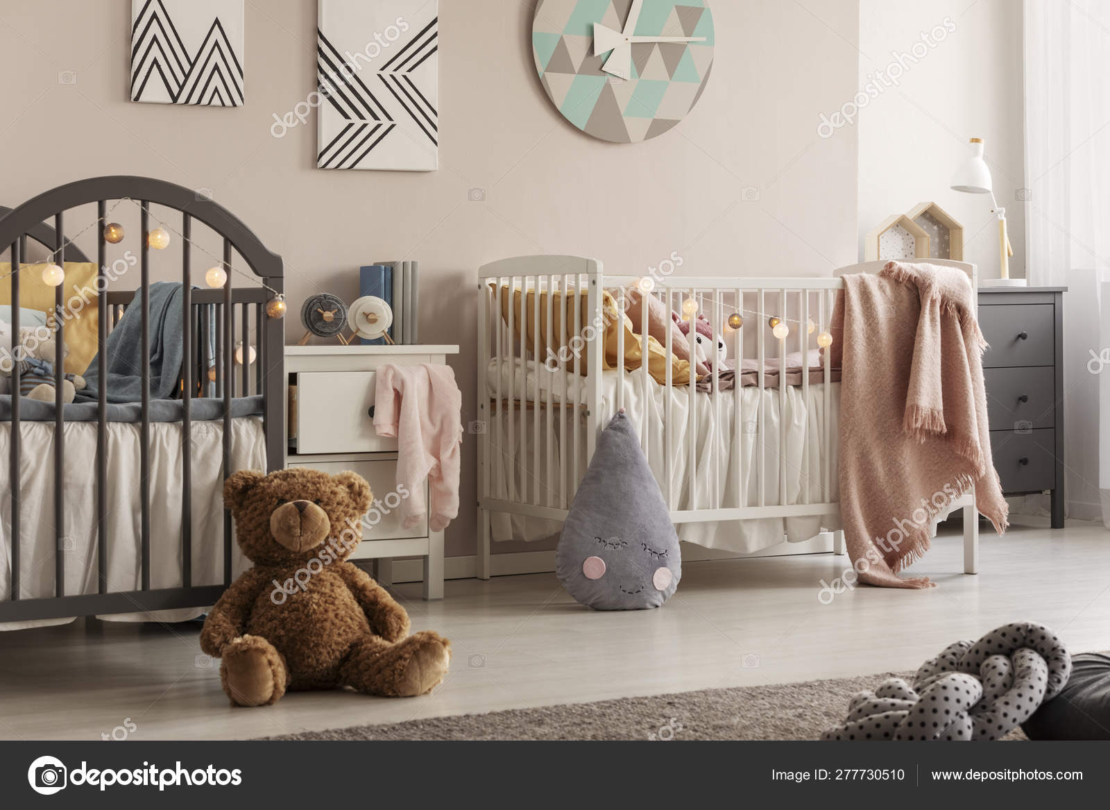 Stylish Baby Bedroom For Twins With Two Cribs And Teddy Bear