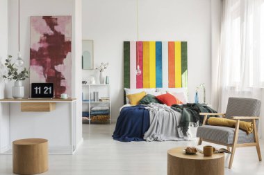 Yastık ve battaniye ve çiçek ile dizüstü bilgisayar ve vazo ile ev ofis ile kral boyutu yatakta Renkli başlık