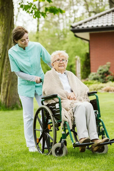 Young female nurse with disabled in the garden — Stock Photo, Image