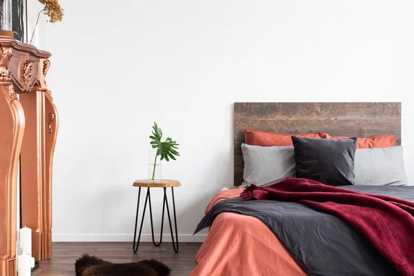 Wit interieur met houten bed, grijs beddengoed, nachtkastje en — Stockfoto