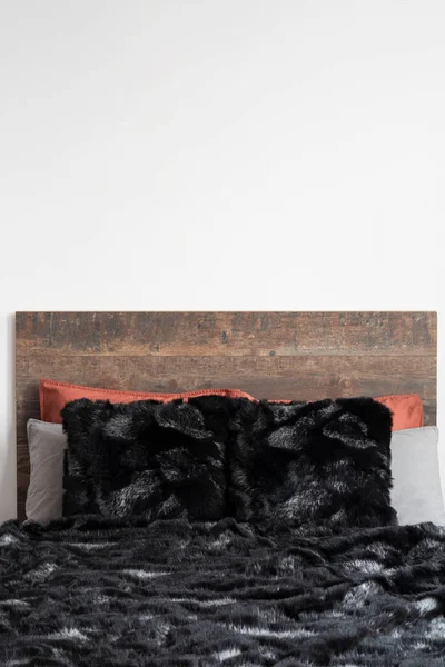 Close capture of black furry blanket on the wooden bed — Stock Photo, Image