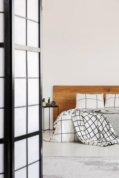 Элегантная спальня с белой стеной и клетчатыми кроватями — стоковое фото