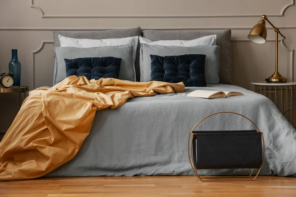 Libro abierto sobre la cama azul en el interior del dormitorio elegante — Foto de Stock