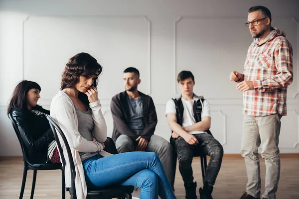 Depressed woman isolating herself from her psychotherapy group in mental hospital — Stock Photo, Image