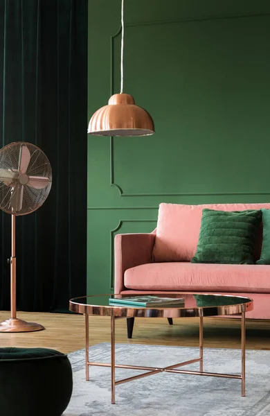 Véritable photo d'une table basse en cuivre, lampe et ventilateur à côté d'un canapé rose poudré dans un salon intérieur — Photo