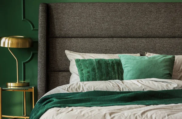 Real photo of green sheets on a comfy bed in an elegant bedroom interior — Stock Photo, Image