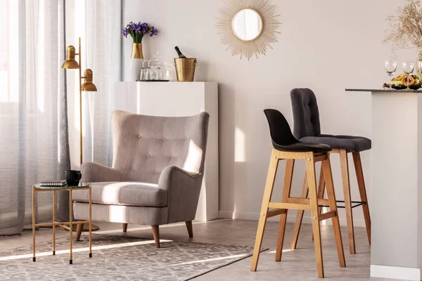 Sillón gris de moda junto a dos taburetes de bar de madera negro en el interior de la cocina y el comedor de moda — Foto de Stock