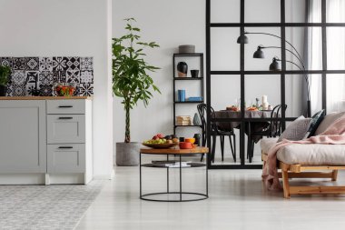 Tencerede bataklık bitki ve sehpa üzerinde şeyler ile beyaz ve siyah minimal mutfak iç