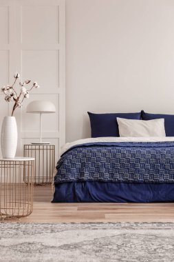 Şık yatak odası iç vazo pamuk çiçekleri ile beyaz endüstriyel lamba ve trendy başucu masa ile şık komedite