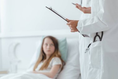 Doktor bir çocuğa tanının ne olduğunu anlatıyor.