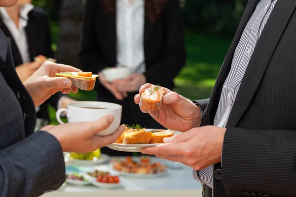 Two businesspeople with coffee and sandwiches during outdoor business lunch — Stock Photo, Image