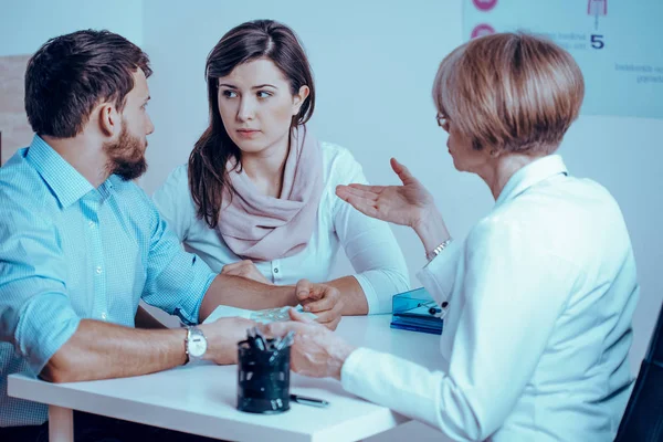 Pareja preocupada consultando con doctora sobre terapia médica —  Fotos de Stock