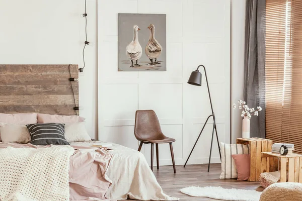 Cute poster with two ducks on white wall of tasteful bedroom interior with bed with pastel pink bedding — Stock Photo, Image