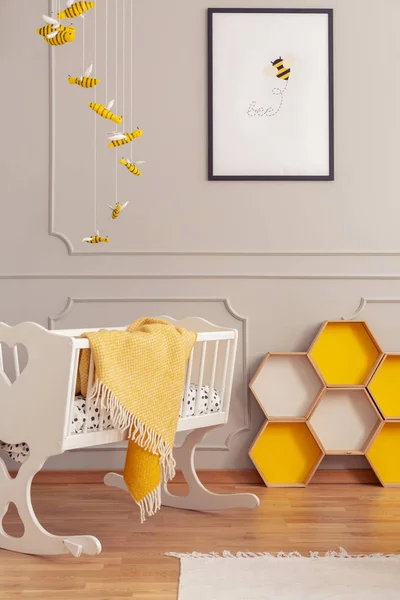 Cot dengan selimut dan sarang lebah kuning di interior ruangan anak-anak. Foto asli — Stok Foto