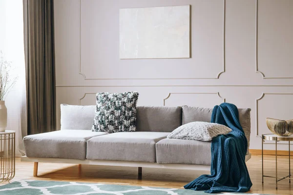 Manta azul sobre sofá gris en elegante salón interior — Foto de Stock