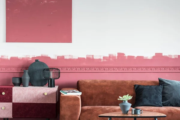 Элегантный интерьер гостиной с коричневым диваном и белой и красной цокольной стеной — стоковое фото