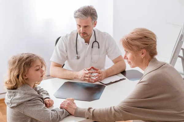 Mutter und süßer kranker Sohn vor dem hübschen Kinderarztpult — Stockfoto