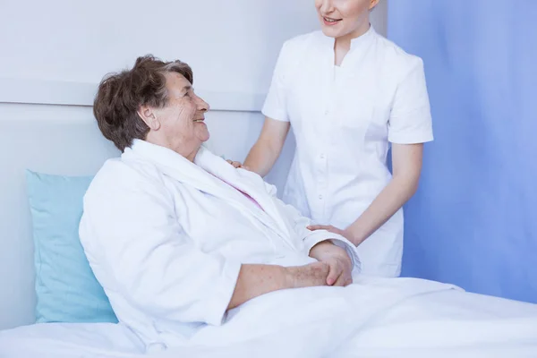 Giovane bella medico femminile e paziente anziano in ospedale — Foto Stock