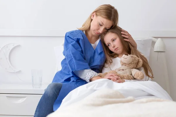 Doente menina triste e mãe com medo no hospital — Fotografia de Stock
