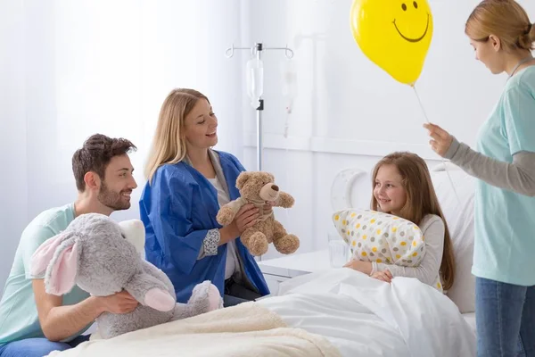 Voluntário no hospital fazendo a menina doente feliz — Fotografia de Stock