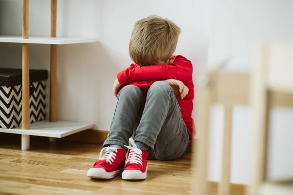 Criança com depressão se senta no canto da sala, e perder o interesse em atividades e trabalhos escolares — Fotografia de Stock