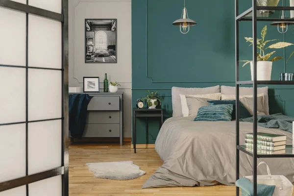 Kopieerruimte op lege groene muur van modieuze slaapkamer interieur met warm beddengoed — Stockfoto
