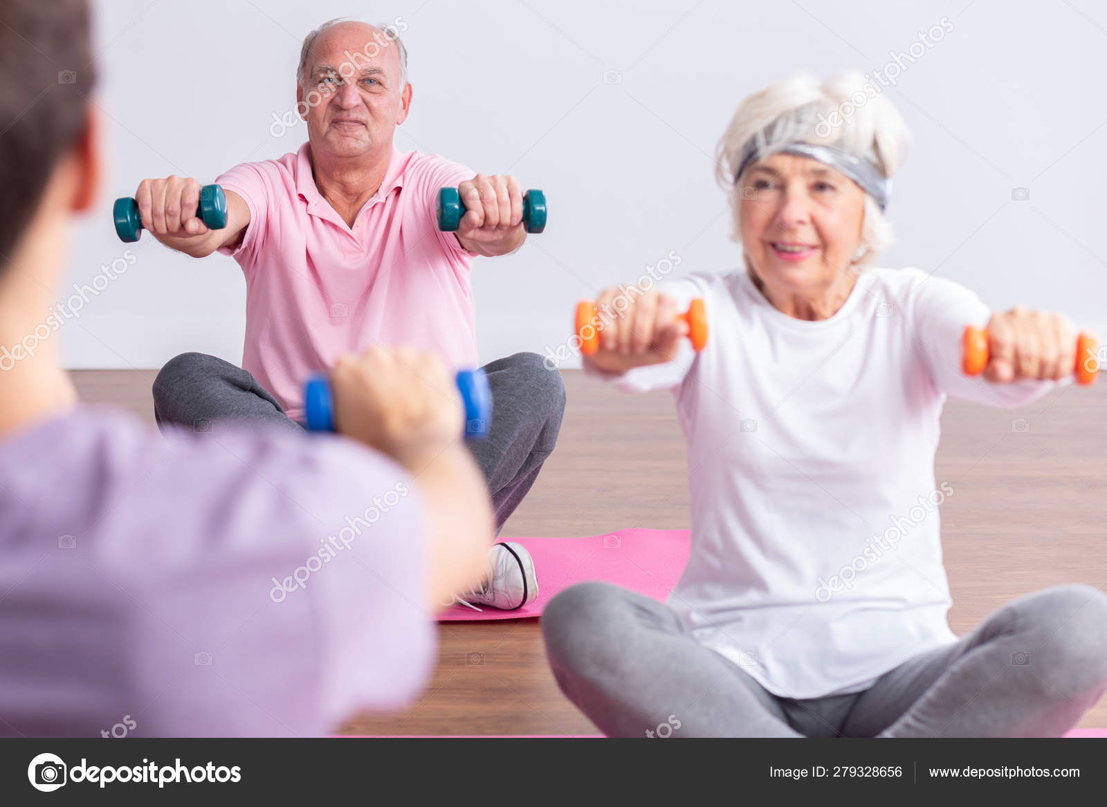 Elderly man and woman during wellness seniors workout at gym Stock