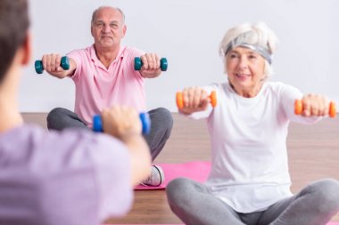 Yaşlılar spor salonunda yaşlılar antrenman yapıyor.