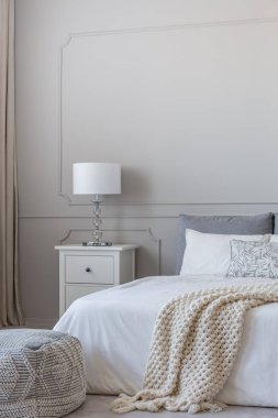 Rahat yatak ile rahat kral yatak yanında iki çekmeceli ahşap gece masa üzerinde basit beyaz lamba