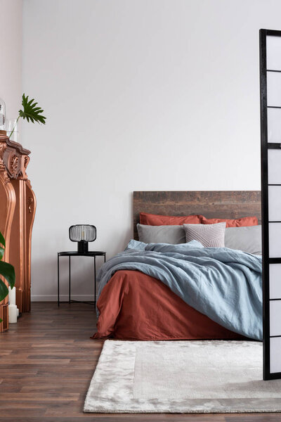 Вертикальный кадр промышленной спальни с паркетными полами, медь
