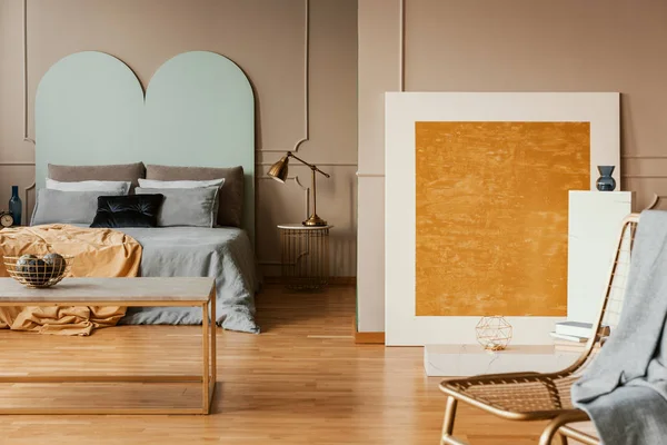 Pittura astratta arancione in camera da letto elegante con lenzuola blu — Foto Stock