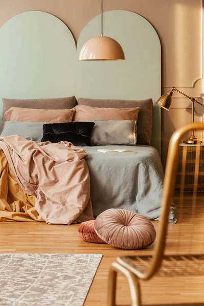 Pastello rosa elegante lampada sopra comodo letto con biancheria da letto accogliente — Foto Stock