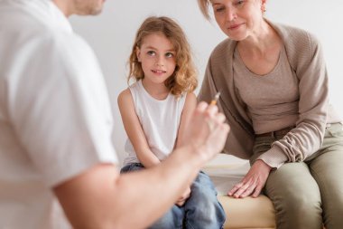Onun sevgi dolu annesi ile pediatrist ofisinde grip ile hasta sevimli küçük çocuk