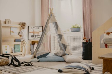 Kilim ve ahşap mobilya, gerçek fotoğraf ile rahat oyun odası iç Gri İskandinav çadır ve yastıklar