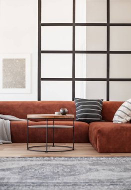 Kahverengi köşe kanepe ile trendy oturma odası iç duvarında beyaz çerçeve gümüş soyut boyama