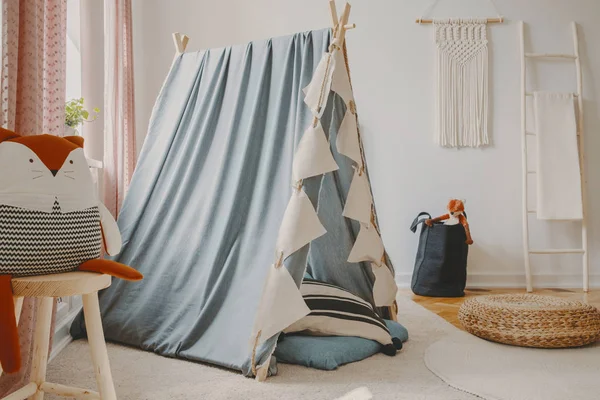 Sala de juegos natural con carpa escandinava azul, muebles de madera y macramé hecho a mano en la pared, foto real — Foto de Stock