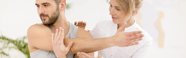 Panoramic view of handsome young man during kinesiotherapy after car accident — Stock Photo, Image