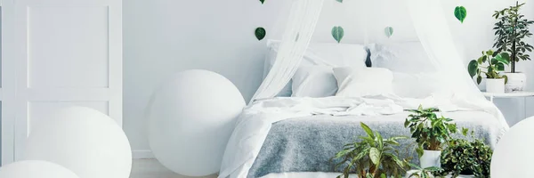 Panoramatický pohled na bílou a zelenou ložnici s nebesy a s kalhotami na posteli — Stock fotografie