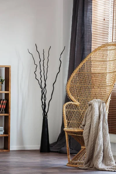 Плетене павичеве крісло з ковдрою в комфортному інтер'єрі спальні зі скандинавським дизайном — стокове фото