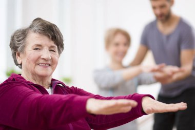 Hastane fizyoterapi merkezinde egzersiz kıdemli gri kadın