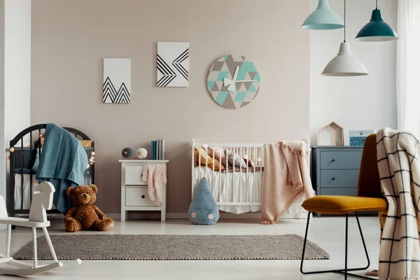 Grijze wieg met blauwe deken in de hoek van de stijlvolle baby slaapkamer — Stockfoto