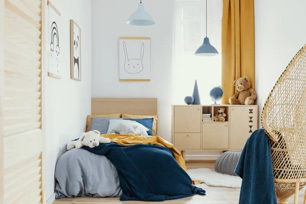 Стильний дерев'яний комод в яскравому інтер'єрі спальні з плакатом на стіні — стокове фото