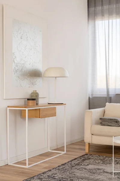 Bílá průmyslová lampa, fotografie v rámu a rostlina v hrnci na dřevěném stolku v elegantní obývací místnosti s bílou zdí — Stock fotografie
