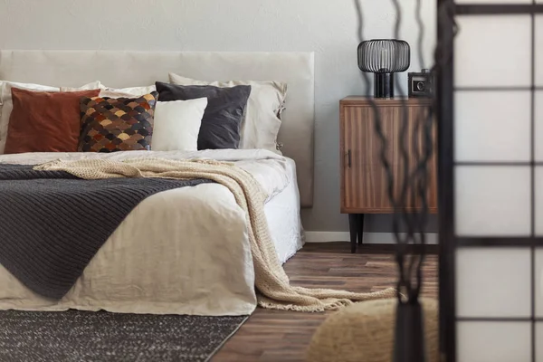 Armario de madera vintage junto a la cama king size con almohadas y manta en el interior del dormitorio de moda —  Fotos de Stock