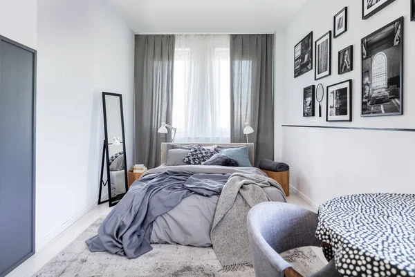 Cozy pillows on comfortable big king size bed in bright bedroom interior in elegant apartment — Stock Photo, Image