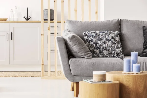 Zwei holzblockförmige Couchtische mit Knicks vor grauen skandinavischen Sofas mit Kissen — Stockfoto