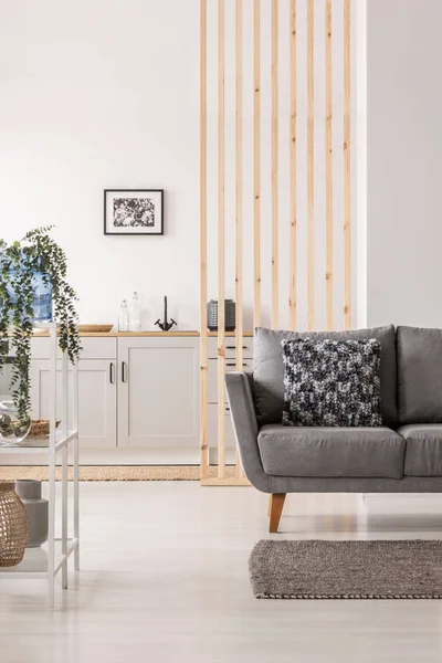 Soggiorno e cucina open space interni con armadi bianchi e divano grigio con cuscini — Foto Stock