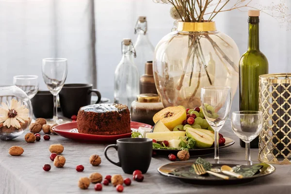 Gemeinsamer Esstisch mit Essen, Obst, Kuchen und Blumen in der Vase — Stockfoto